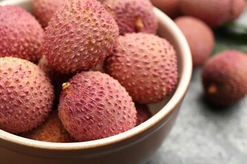 Fresh ripe lychee fruits in bowl on table, closeup