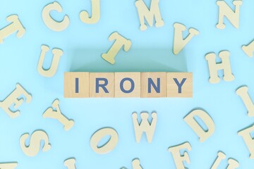 Irony figure of speech concept in English grammar class lesson. Wooden blocks typography flat lay...