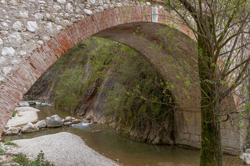 ancient bridge in the "Valle delle Cartiere" in toscolano maderno, bridge over a river immersed in the green of nature