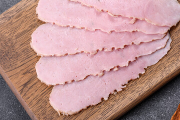 Sliced ham on wooden background. Fresh prosciutto. Pork ham sliced