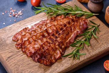 Delicious roasted ham with slices on a wooden cutting board with spices and herbs