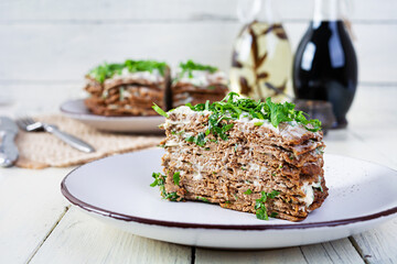 Liver cake on wooden background. Sliced layered liver cake with mayonnaise