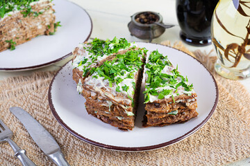 Liver cake on wooden background. Sliced layered liver cake with mayonnaise