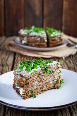 Liver cake on wooden background. Sliced layered liver cake with mayonnaise