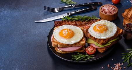 Fresh, delicious sandwiches with fried egg, ham, butter, avocado and sesame seeds