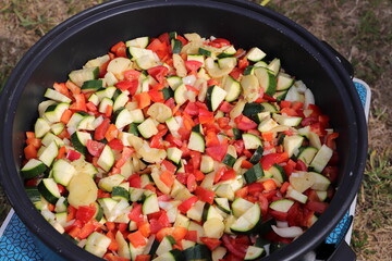 a vegetable pan with courgettes, onions, tomatoes, potatoes and peppers