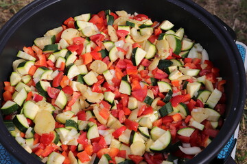 a vegetable pan with courgettes, onions, tomatoes, potatoes and peppers