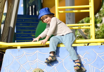 Funny kid on the playground. The child plays in the yard, in the kindergarten.