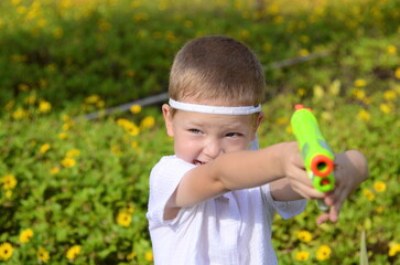 Cute ninja boy with a water gun. Concept: summer holidays, preschooler, kindergarten, summer fun, children's toys