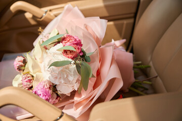 Close-up of beautiful bouquet lies on leather car seat