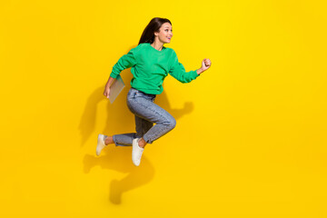 Fototapeta na wymiar Full body portrait of active sporty lady hold netbook jump rush empty space isolated on yellow color background
