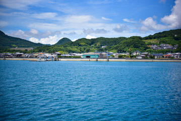 真っ青に晴れた空と穏やかな海に囲まれた緑豊かで小さな港と人々の暮らし