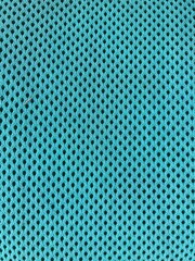 a turquoise green blue uniform woven fabric surface with small black holes