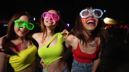 4K Group of Asian woman celebrating and dancing together at tropical island beach full moon party at night. Happy girl friends enjoy outdoor lifestyle beach holiday summer travel vacation in Thailand