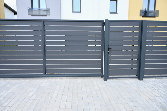 Modern gray metal fence for fencing the yard area. Horizontal metal sections of the fence. Close up