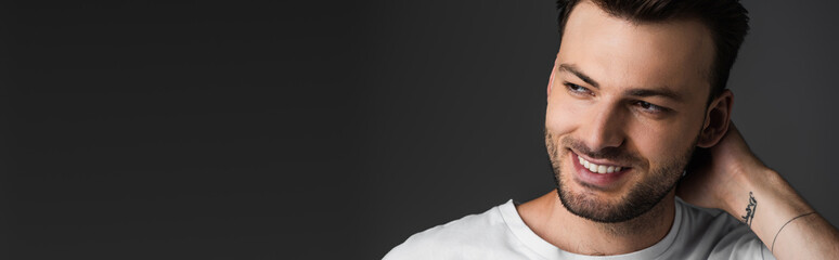 Obraz premium Brunette man touching neck and looking away isolated on grey, banner.