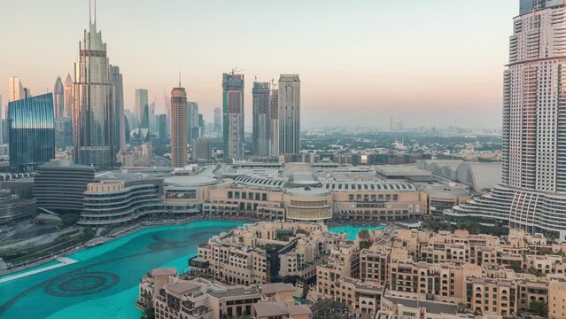 Aerial view of Dubai International Financial Centre district during sunset timelapse. Office towers and hotels with modern skyscrapers and shopping mall in downtown. Old town historic houses