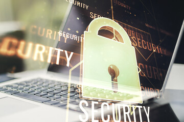 Double exposure of creative lock hologram with chip on laptop background. Information security...