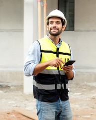 Male architect or engineer using mobile phone for communication while working at construction site....