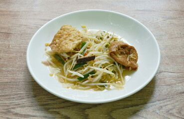 fried bean sprout with slice egg tofu and chop pork in plate on table