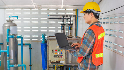 Engineer working in drinking water factory using a tablet computer to check water management system and boiler water pipe in water factory