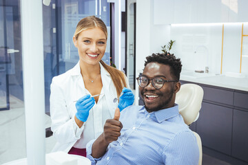 My dentist is the best! Portrait of a female dentist and young man in a dentist office. Happy...