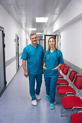 Two doctors stand together in the hospital and smile