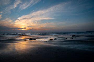Obraz premium a heart shaped puddle next to the petrified forest on Borth beach during sunset 