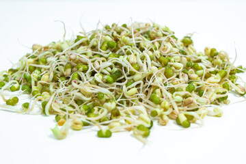 Mound of sprouted mung beans  (Vigna radiata) with small roots ofor eating. White background. Close up.