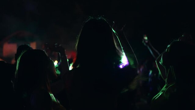 4K Group of Asian woman celebrating and dancing together at tropical island beach full moon party at night. Happy girl friends enjoy outdoor lifestyle beach holiday summer travel vacation in Thailand