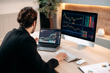 Successful caucasian male trader investor, analysing cryptocurrency financial market, focused looks at a screen, planning a crypto strategy, analyzing risks. Investments, trading on the stock exchange
