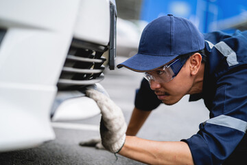 A mechanic in a safety suit is working on a damaged motor vehicle on site. Repair and Service Concepts .Professional car mechanic. service technician