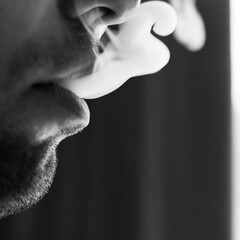 Seductive male lips blowing cigarette smoke.