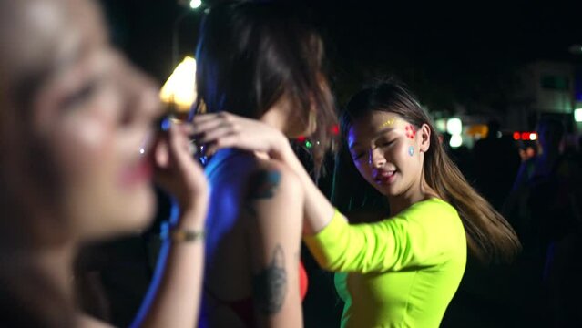 4K Group of Asian woman celebrating and dancing together at tropical island beach full moon party at night. Happy girl friends enjoy outdoor lifestyle beach holiday summer travel vacation in Thailand
