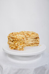 Napoleon cake in a cut on a white tray isolated on a white background. Cake of puff pastry with sour cream. Copy space. 