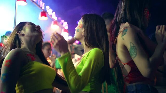 4K Group of Asian woman celebrating and dancing together at tropical island beach full moon party at night. Happy girl friends enjoy outdoor lifestyle beach holiday summer travel vacation in Thailand