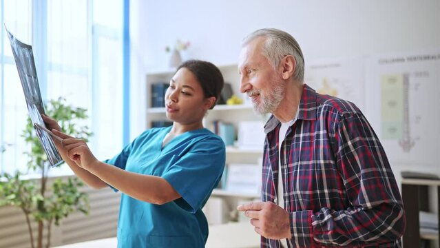 Nice female rehabilitation clinic doctor talking with her patient, medicine
