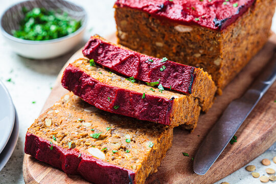 Lentil vegan meat oaf sliced on wooden board. Christmas recipe.