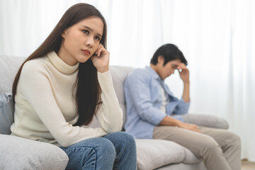 Naklejka na ściany i meble Family problems, Asian women cover her face and sit separately from husband feel disappointed after quarrels at home.