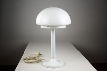 modern desk lamp with mushroom shape spaceage vintage midcentury design front side view white black background with warm orange light isolated in the studio living room creative HIGH RESOLUTION