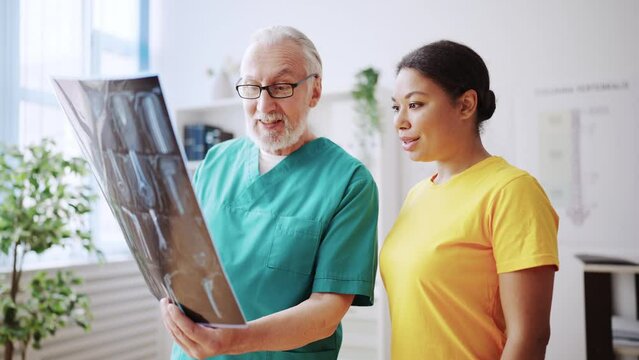 Doctor and his patient looking at x-ray picture together, diagnostic center