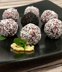 Round handmade candies made of dried fruits and pine nuts, cranberries, coconut. Suitable for vegans and the keto diet. A traditional Portuguese sweet.