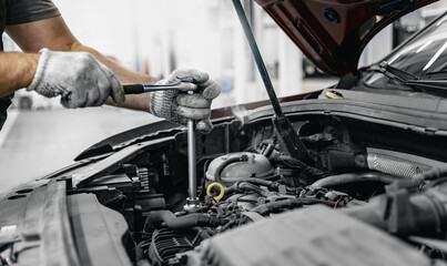 Fototapeta na wymiar Mechanic in repairing car, change motor oil in auto service garage