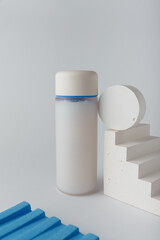 White bottle with concrete decor. Cosmetics container mockup, template. Face skin care, body lotion, shampoo or hair conditioner