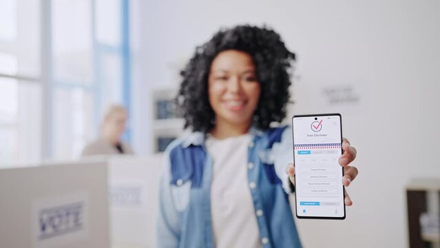 African American woman showing smartphone with application for online voting