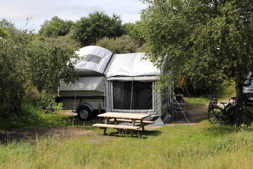 an old folding caravan on a campsite 