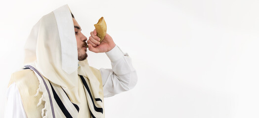 Blowing the Shofar - man in a tallith, Jewish prayer shawl is blowing the shofar ram's horn. - obrazy, fototapety, plakaty