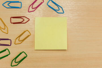 Yellow post it with colorful paper clips on the left side