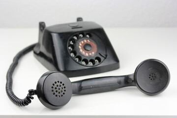 old antique dial operated telephone black out of bakelite on white background isolated side view...