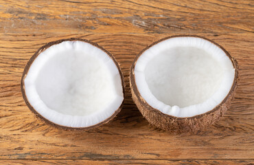 Cracked coconut half fruit over wooden table